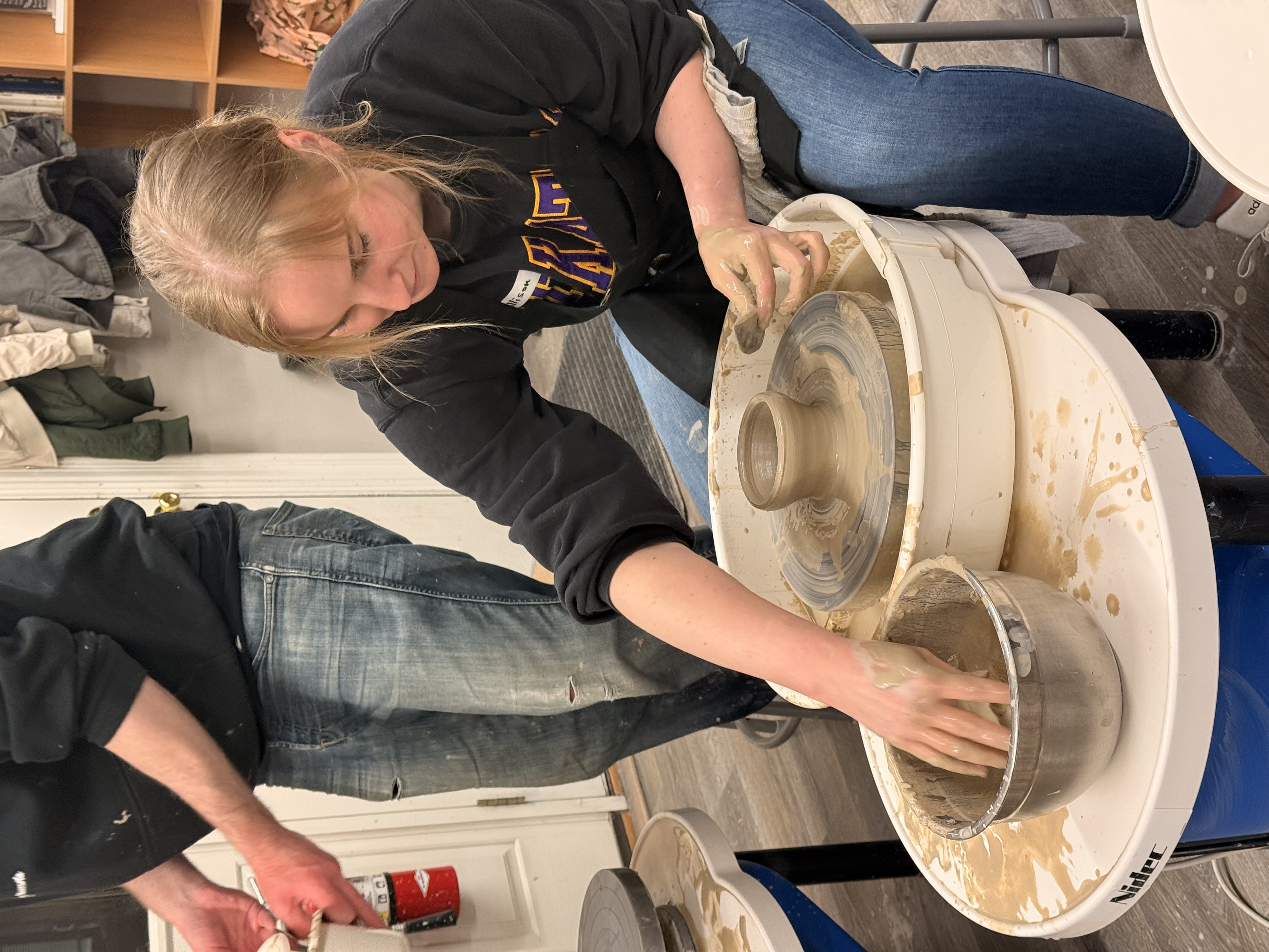 Intro to pottery wheel class participant learning to make a small bowl